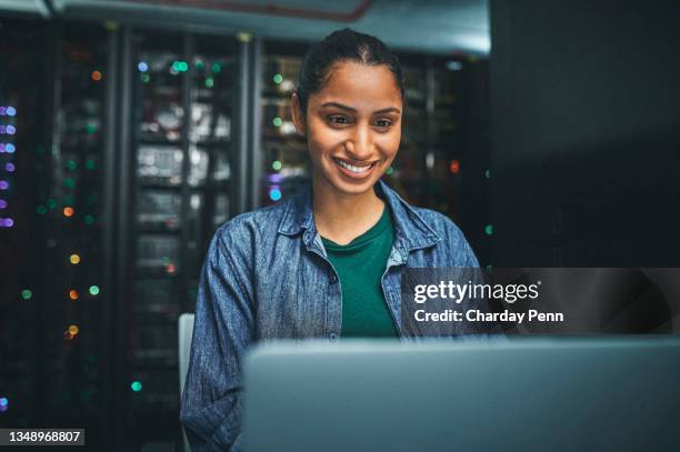 shot of an female it technician in a server room and using a laptop - solutions expertise stockfoto's en -beelden