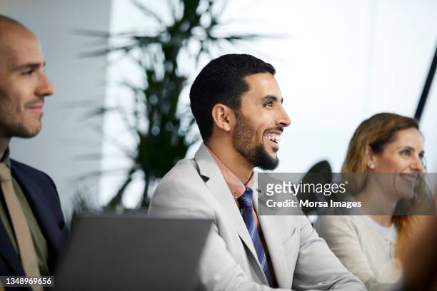 smiling businesswoman with colleagues in meeting - israelischer abstammung stock-fotos und bilder