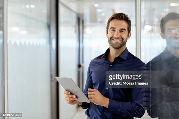 portrait of smiling executive with digital tablet - ejecutiva fotografías e imágenes de stock