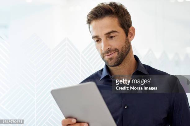businessman looking at digital tablet in office - holding laptop stock pictures, royalty-free photos & images