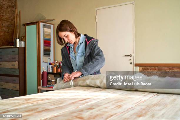 woman selects fabrics for new job upholstery workshop. - creative selects part i fotografías e imágenes de stock
