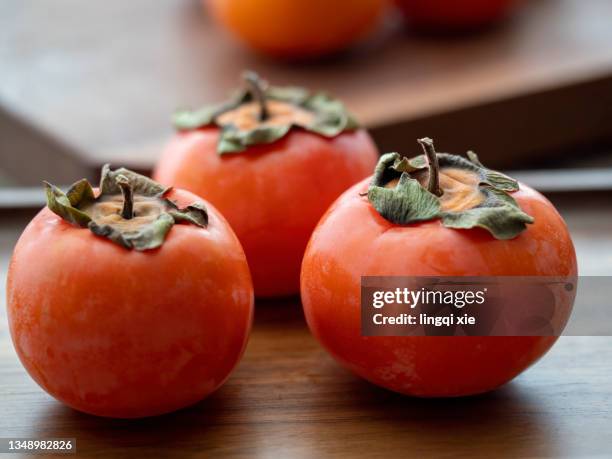 ripe persimmons in autumn - kaki stock-fotos und bilder