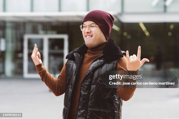 chinese man doing a rock gesture - schmerzfrei stock-fotos und bilder