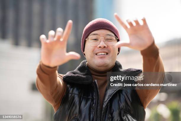 asian man makes photo gesture - filmregisseur stock-fotos und bilder