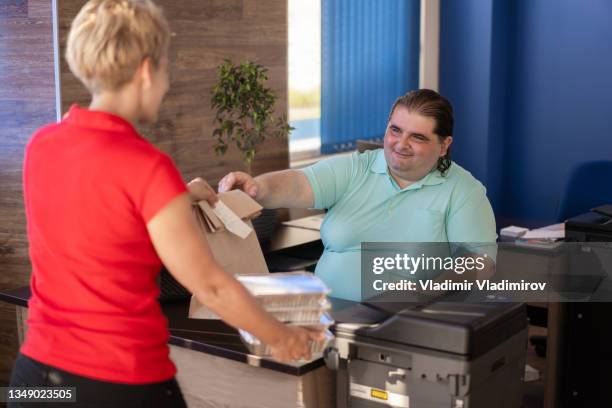 courier handing over food delivery in office - large printer stock pictures, royalty-free photos & images