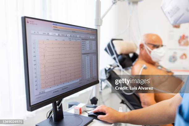 computer monitor showing cardiac stress test results of a senior male patient in the clinic. - heartbeat foto e immagini stock