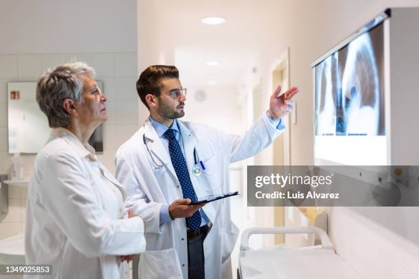 two doctors analyzing x-ray image in hospital - cardiology stock pictures, royalty-free photos & images