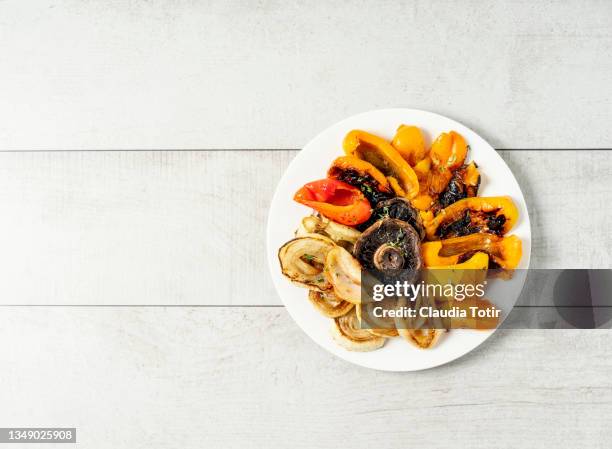 grilled vegetables (bell pepper, mushrooms, and onion) on a plate on white, wooden background - roasted pepper stock pictures, royalty-free photos & images