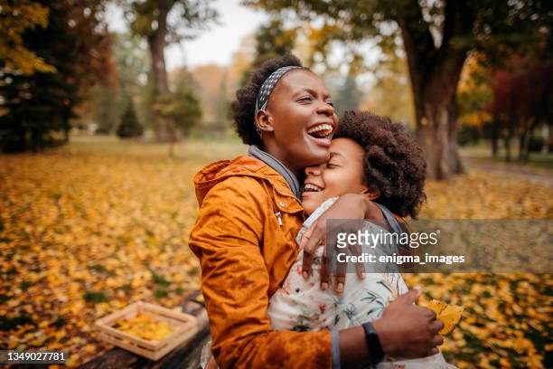 mother and daughter in the park enjoying the beautiful autumn nature - october stock pictures, royalty-free photos & images