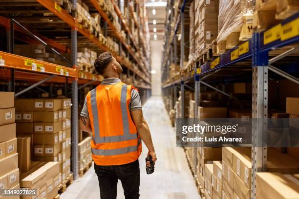 worker in reflective clothing working in the warehouse - entrepôt photos et images de collection