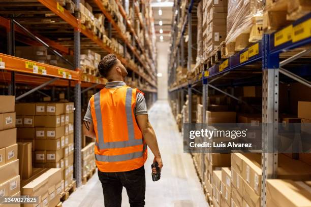 worker in reflective clothing working in the warehouse - armazém imagens e fotografias de stock