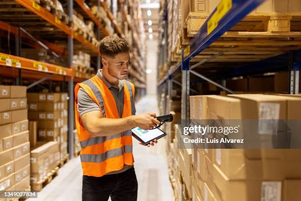 worker scanning package with bar code reader - distribution warehouse stockfoto's en -beelden