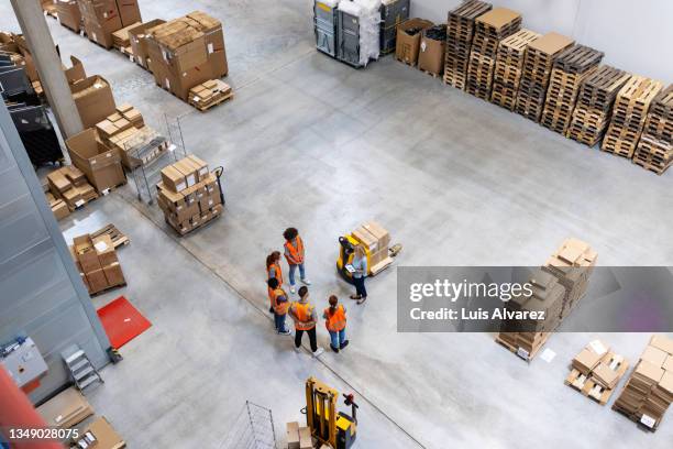 high angle view of warehouse dispatch team meeting - logistics warehouse stock-fotos und bilder