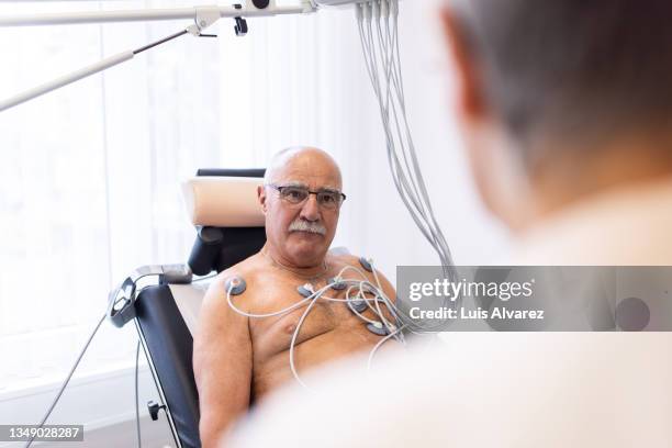 senior man having cardiac stress test in clinic - kardiologie stock-fotos und bilder