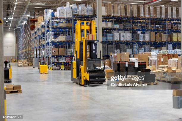 interior of a distribution warehouse with fork lift and large storage racks - building story stock pictures, royalty-free photos & images