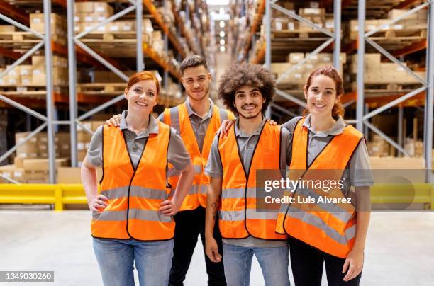 portrait of logistics team standing together in distribution warehouse - leuchtbekleidung stock-fotos und bilder