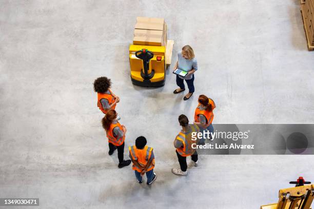 manager planning delivery schedule in meeting with warehouse workers - senior public transportation stock pictures, royalty-free photos & images