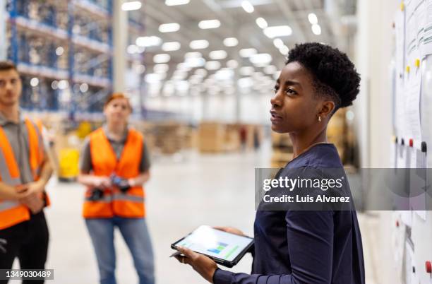 supervisor discussing dispatch plan with workers - logistics warehouse stockfoto's en -beelden