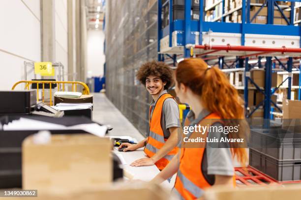 factory warehouse workers working together at their desk - ergonomia foto e immagini stock