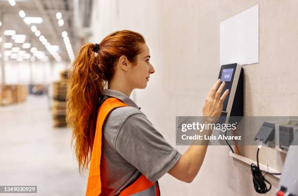 woman worker uses a biometric machine in warehouse - biometrics stock pictures, royalty-free photos & images