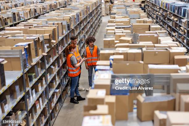 multiracial warehouse workers discussing inventory in the warehouse. - obter inventário imagens e fotografias de stock