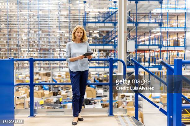portrait of a mature supervisor with digital tablet at warehouse - factory ipad stock pictures, royalty-free photos & images