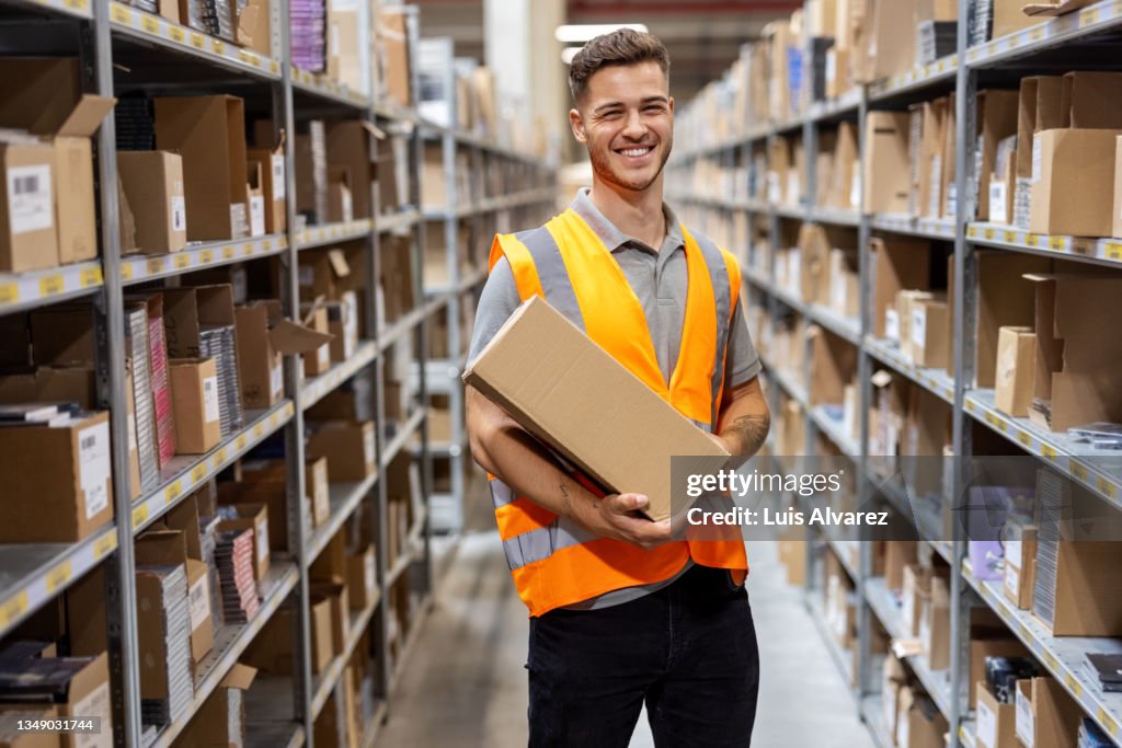 Man working in warehouse arranging boxes on rack