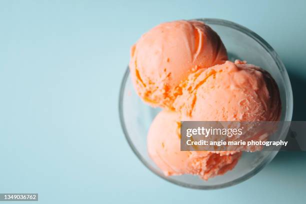 orange sherbet in a bowl - scoop shape stockfoto's en -beelden