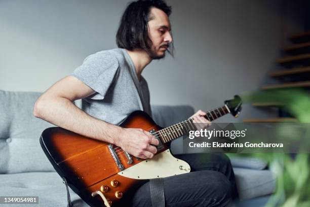 portrait young man at home with an electronic guitar. - エレキギター ストックフォトと画像