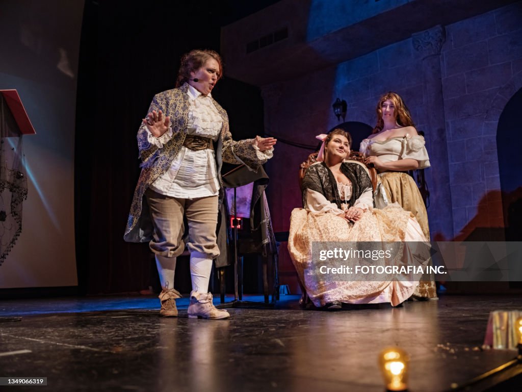 Three Actresses in period costumes on theatre stage