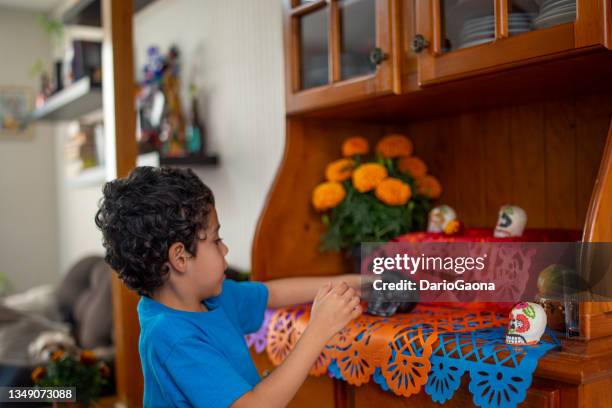 niño poniendo altar de muertos en casa - altar fotografías e imágenes de stock