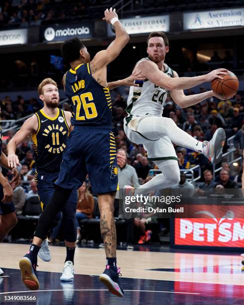 Pat Connaughton of the Milwaukee Bucks passes the ball while being guarded by Jeremy Lamb of the Indiana Pacers in the fourth quarter at Gainbridge...