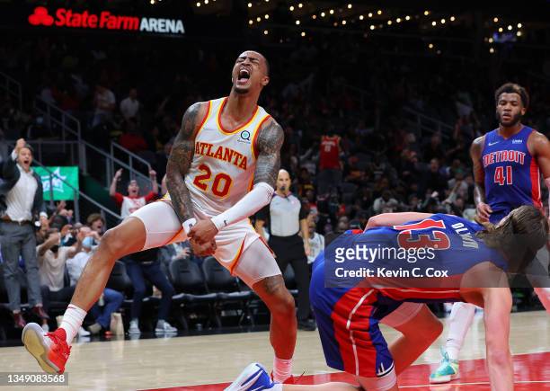 John Collins of the Atlanta Hawks reacts after dunking over Kelly Olynyk of the Detroit Pistons during the second half at State Farm Arena on October...