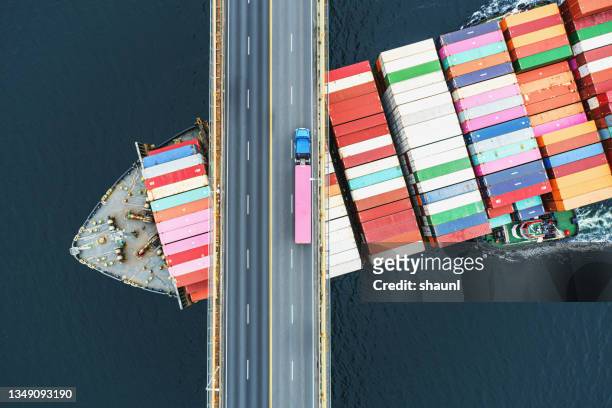 containerschiff unter der brücke - freight transportation stock-fotos und bilder