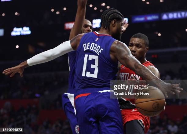 Damian Lillard of the Portland Trail Blazers attempts a pass around Paul George and Nicolas Batum of the LA Clippers during the first half at Staples...