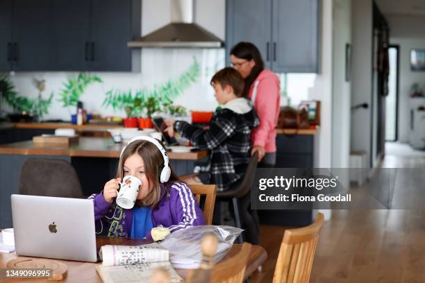 Jessica Matthews, 10 does her school work online in the family kitchen in Warkworth on October 26, 2021 in Auckland, New Zealand. Both Angela...