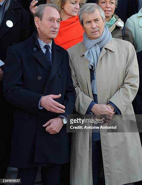 Head of Groupe Bollore, Vincent Bollore whose company is supplying the electric cars, speaks with Paris Mayor Bertrand Delanoe listens at the Autolib...