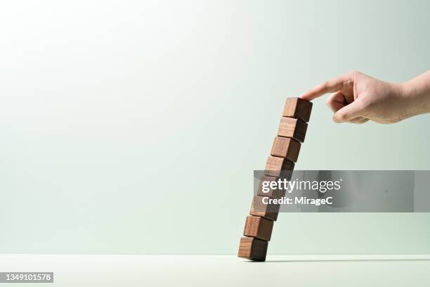 hand stopping stacked blocks from falling down - hazard stock-fotos und bilder