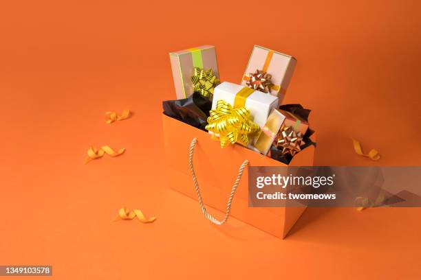 orange colour shopping bags and gift boxes still life. - aansporing stockfoto's en -beelden