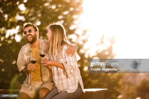 cheerful couple having fun while drinking wine at sunset. - couple laughing hugging bildbanksfoton och bilder