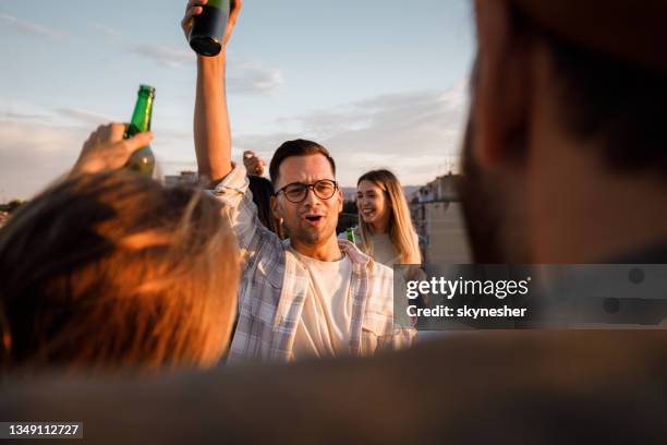 young cheerful friends having fun during a party on a rooftop. - street party stock pictures, royalty-free photos & images