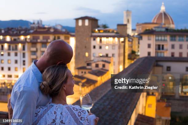couple enjoying a beautiful view of florence at dusk - luxury location stock-fotos und bilder