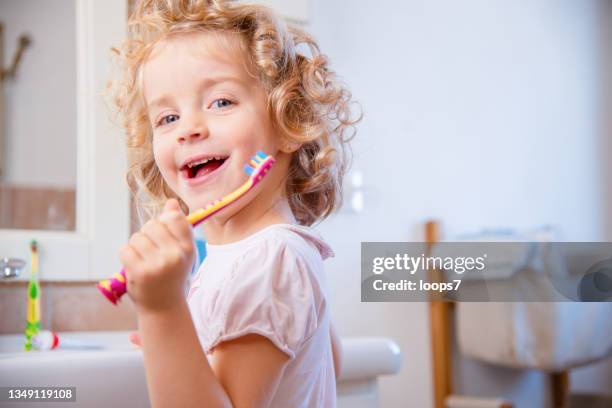 blonde haare fünf jahre altes mädchen lächelt und putzt sich im badezimmer die zähne - man washing his teeth stock-fotos und bilder