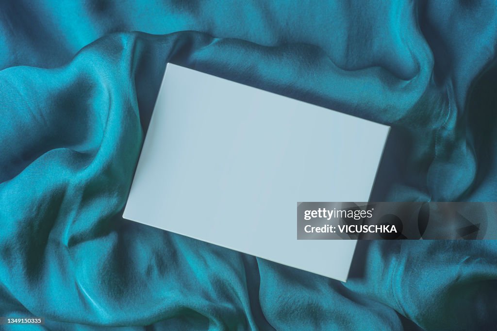 Blank pale blue box with copy space on blue textile background