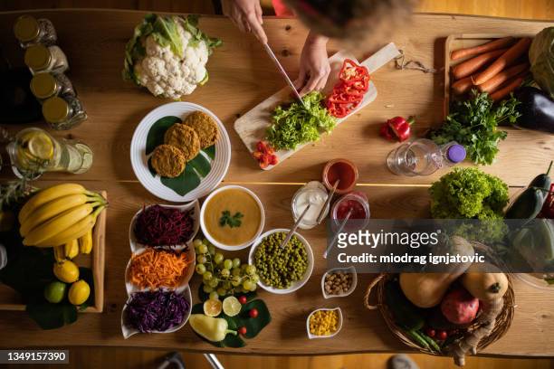 frisches obst, gemüse, kürbissuppe und gemüseburger auf dem tisch - püriert stock-fotos und bilder