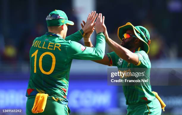 David Miller of South Africa celebrates after taking a catch to dismiss Nicholas Pooran of West Indies with team mate Temba Bavuma during the ICC...