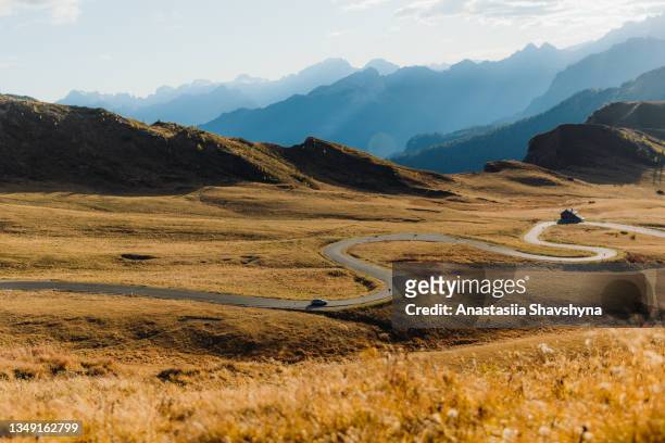 car driving during autumn sunset byc the mountain pass in the alps - church sunset rural scene stock pictures, royalty-free photos & images
