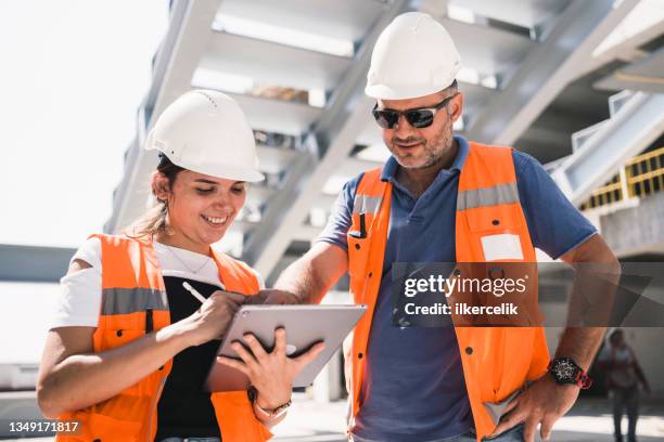 ingenieros civiles verifican obras de acuerdo con el proyecto utilizando una tableta digital en el sitio de construcción - ingeniero civil fotografías e imágenes de stock