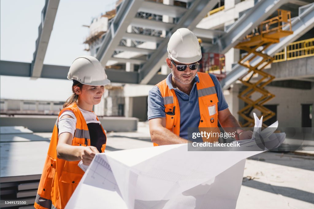 Civil Engineer and Architect Checking The Project According To The Blueprint Drawings At The Construction Site