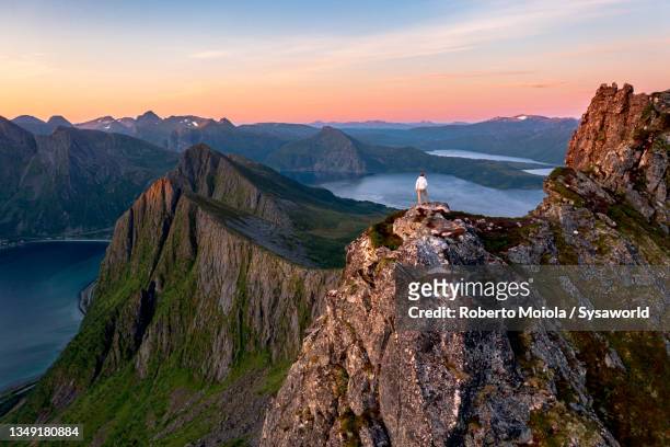 person watching sunrise from mountain peak, norway - drone isolated stock pictures, royalty-free photos & images